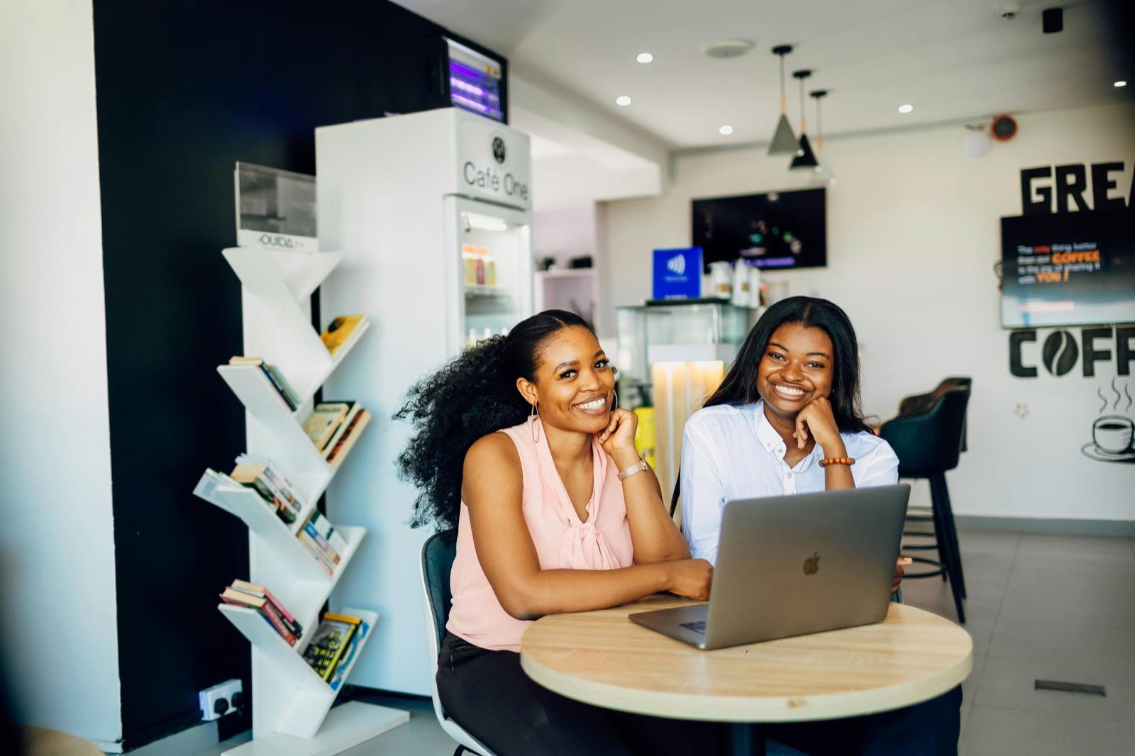 Two sellers smiling over a laptop